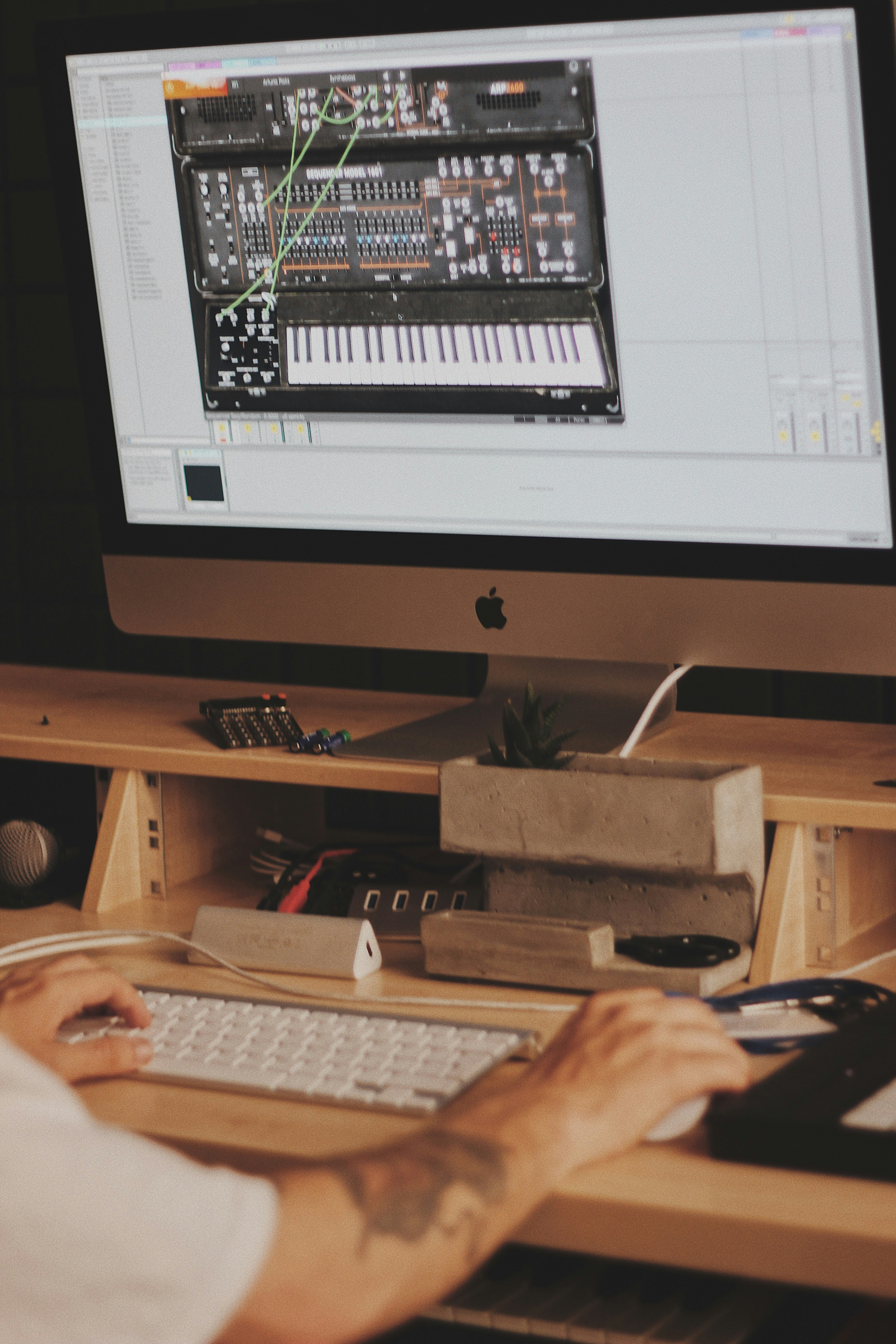 person using iMac computer set with digital piano application